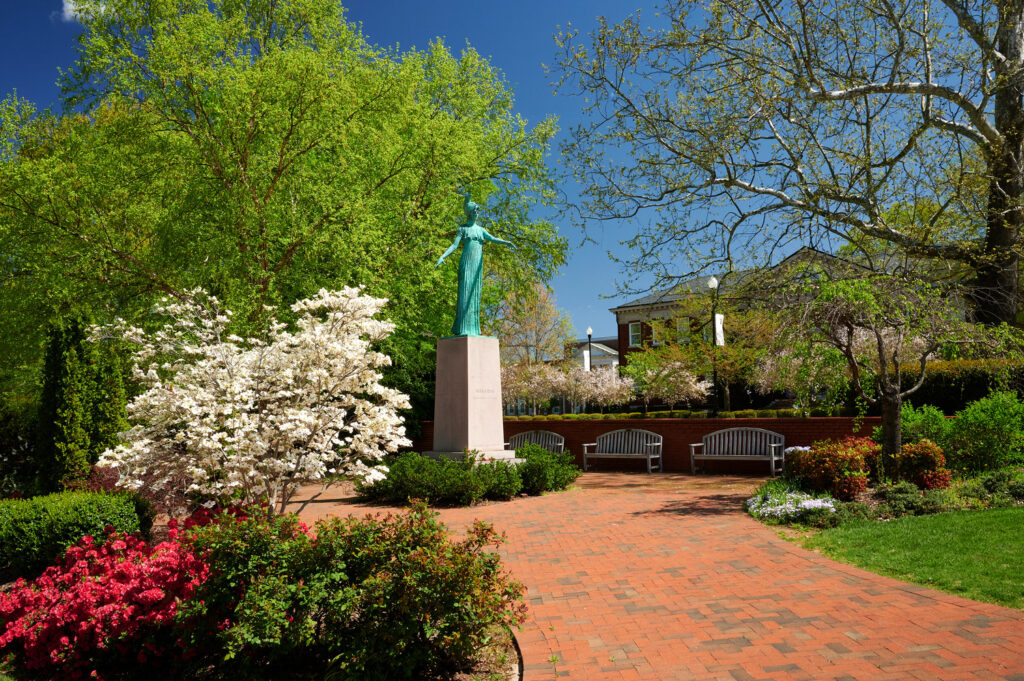 The Minerva statue surrounded by bright spring blooms and foliage
