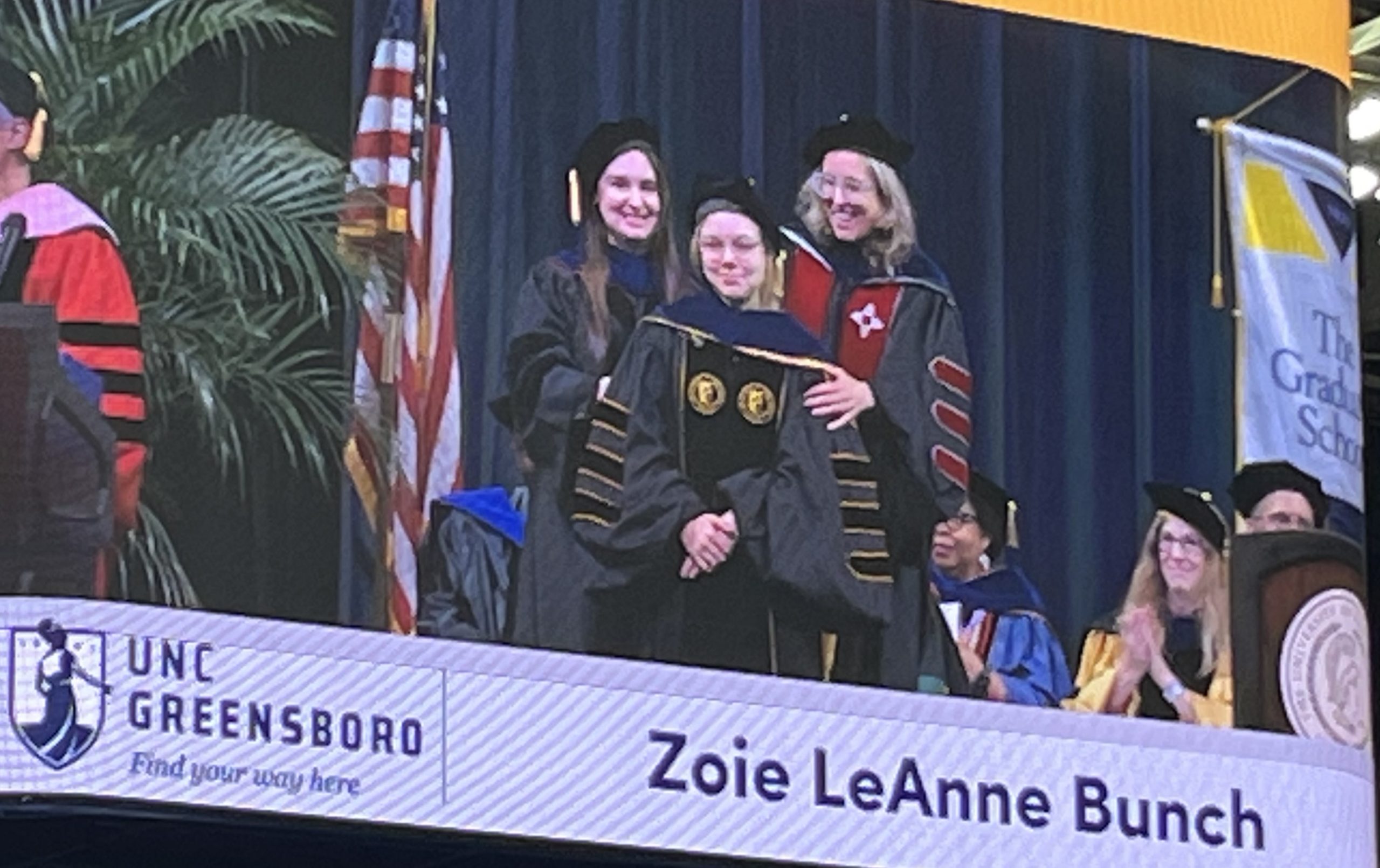 Zoie Bunch on stage with Dr. Popova and Dr. Cech at graduation
